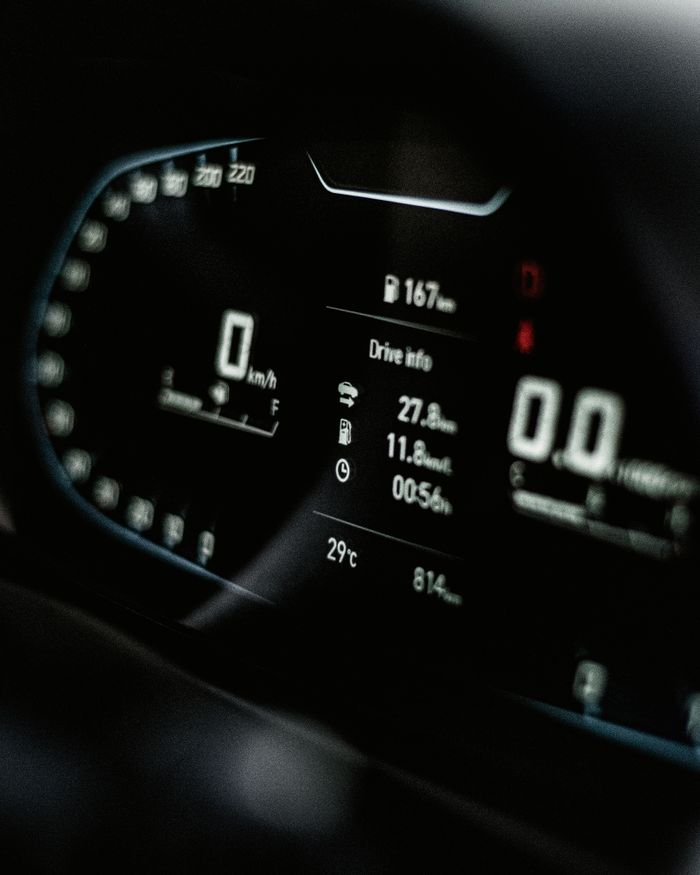 Close-up of a sleek digital car dashboard displaying speed and drive info.